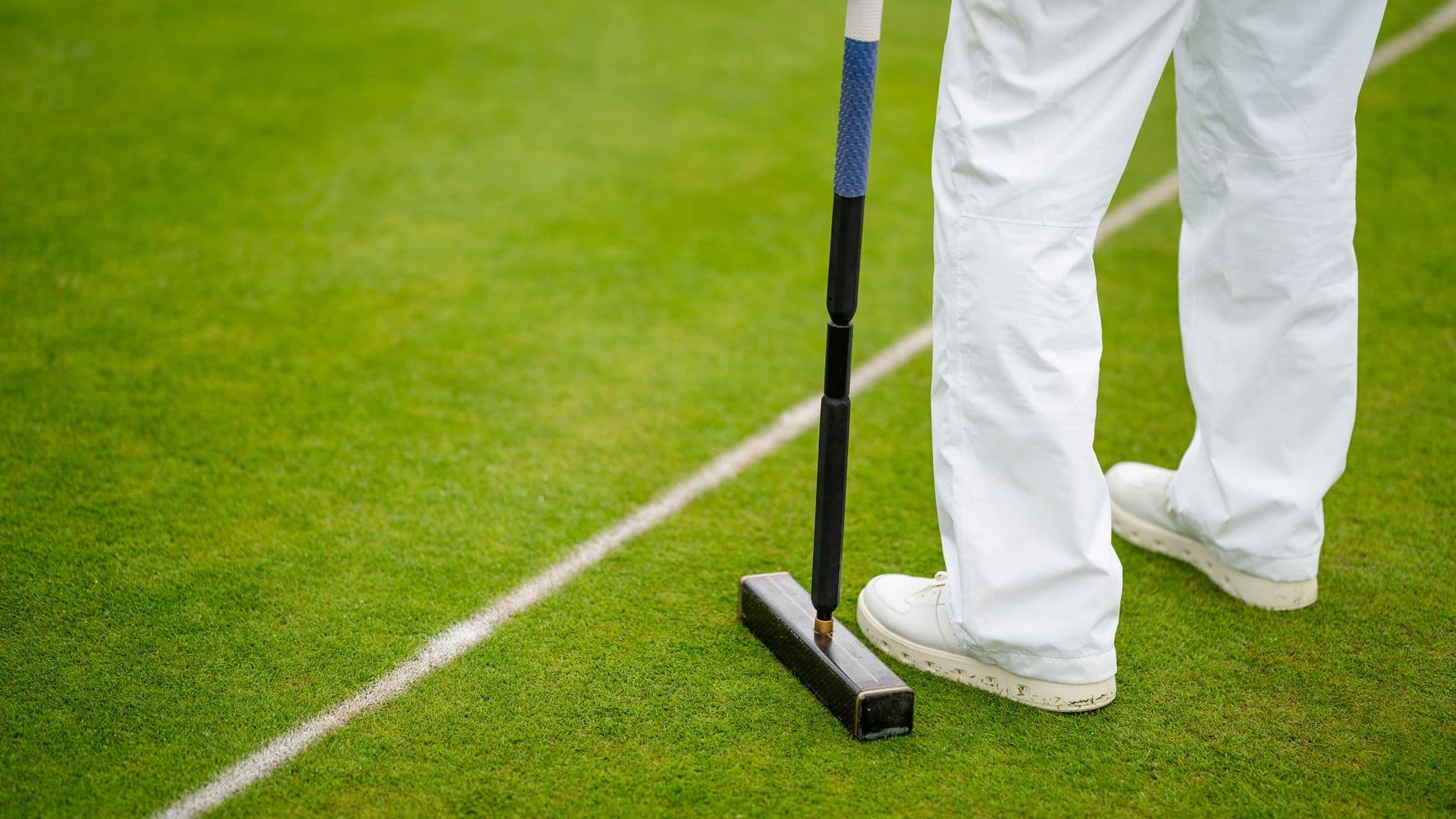 Man standing on croquet lawn with a mallet